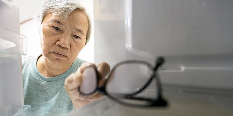 Elderly woman getting her glasses from the freezer