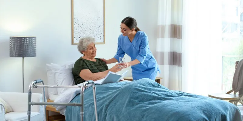 Elderly woman being cared for in her hospital bed